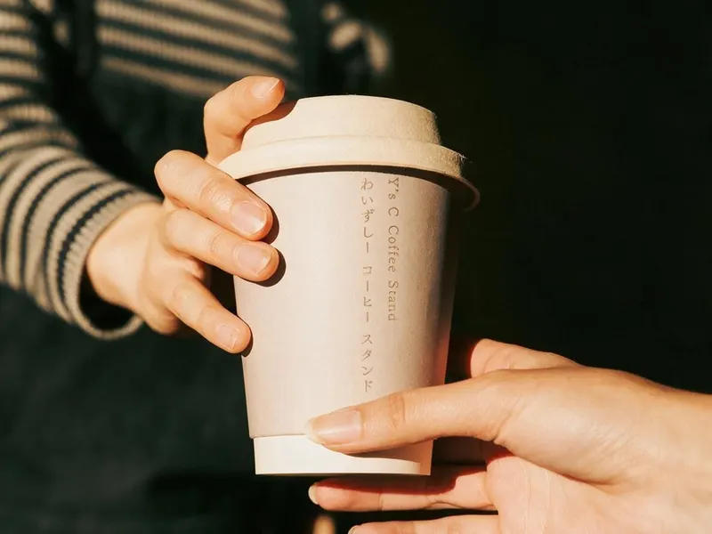 Y’s C COFFEE STAND のカップを手渡すところ